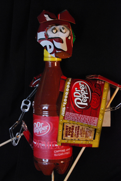 a dog puppet made from a soda bottle with tear away clothing